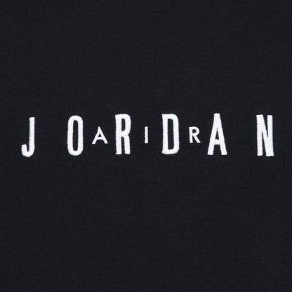 Close-up of embroidered JORDAN wordmark on youth black T-shirt chest
